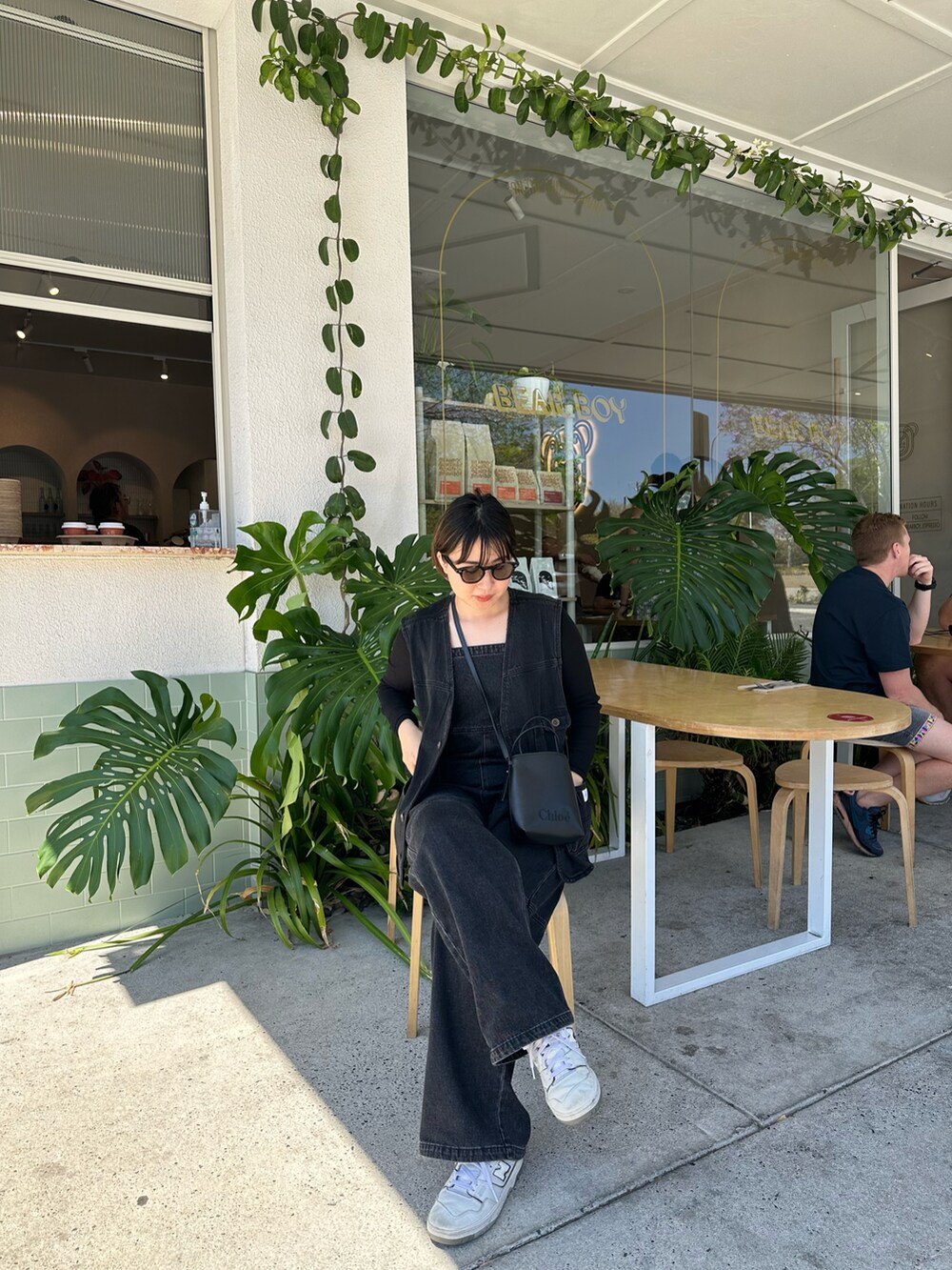 ブラック系のサロペット/オーバーオール、ブラック系のその他アウター、ブラック系のトートバッグを着用したレディースの冬コーディネートの2枚目の写真