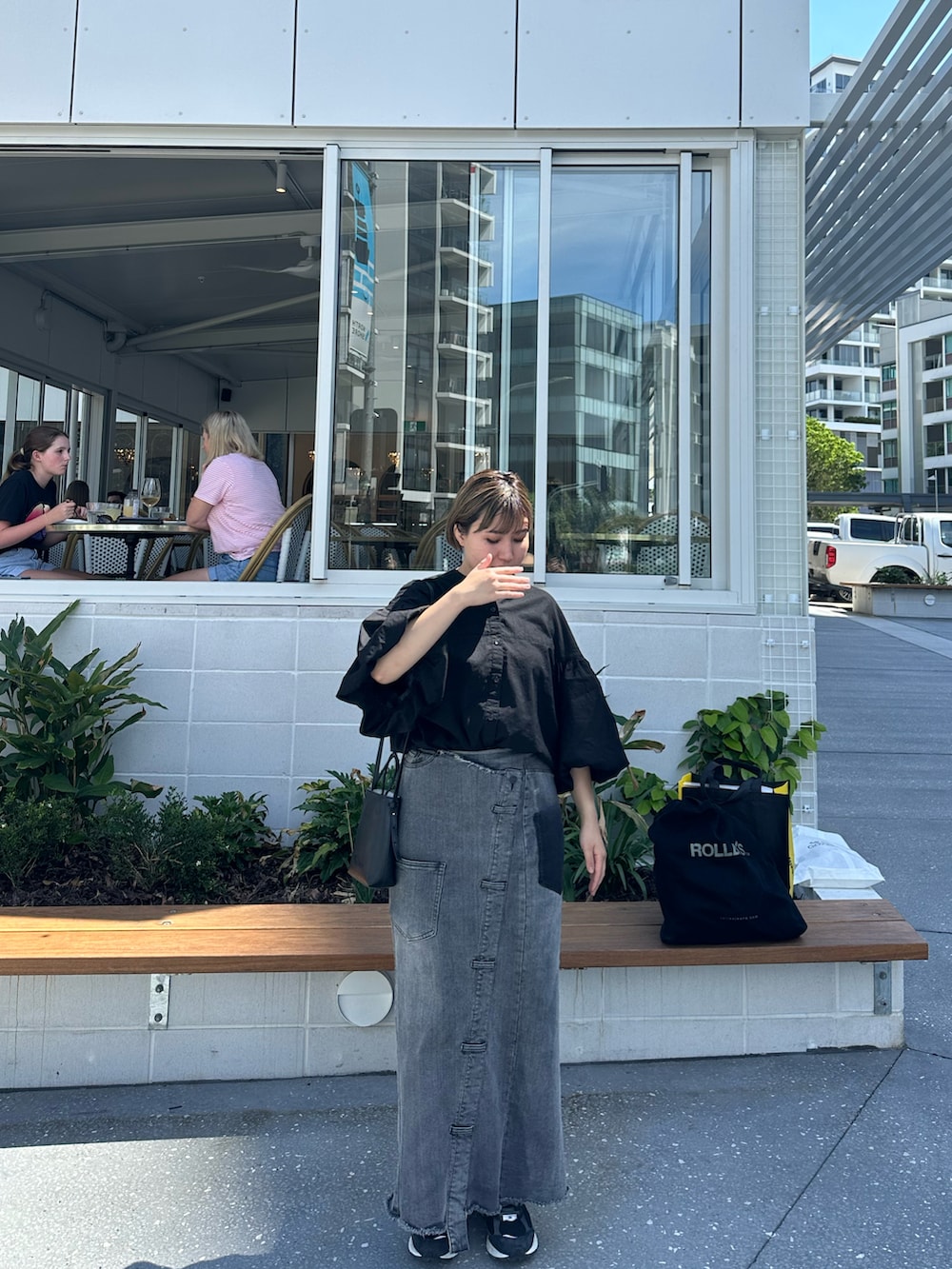 ブラック系のシャツ/ブラウス、ブラック系のデニムスカート、ブラック系のトートバッグを着用したレディースの春コーディネートの3枚目の写真