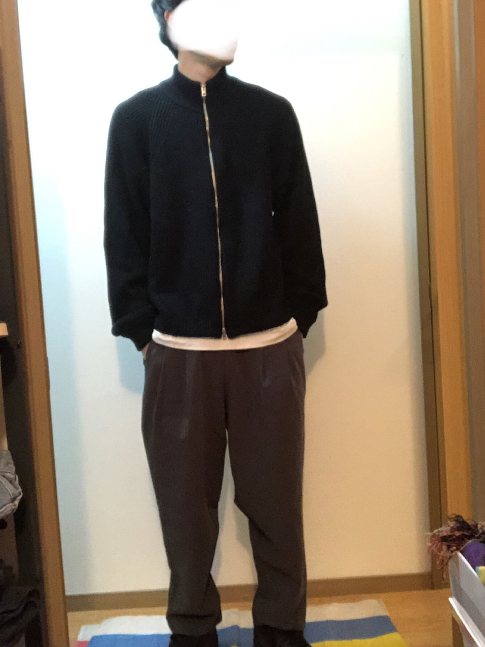 ブラック系のチェスターコート、ブラック系のニット/セーター、グレー系のその他パンツを着用したメンズの冬コーディネートの3枚目の写真