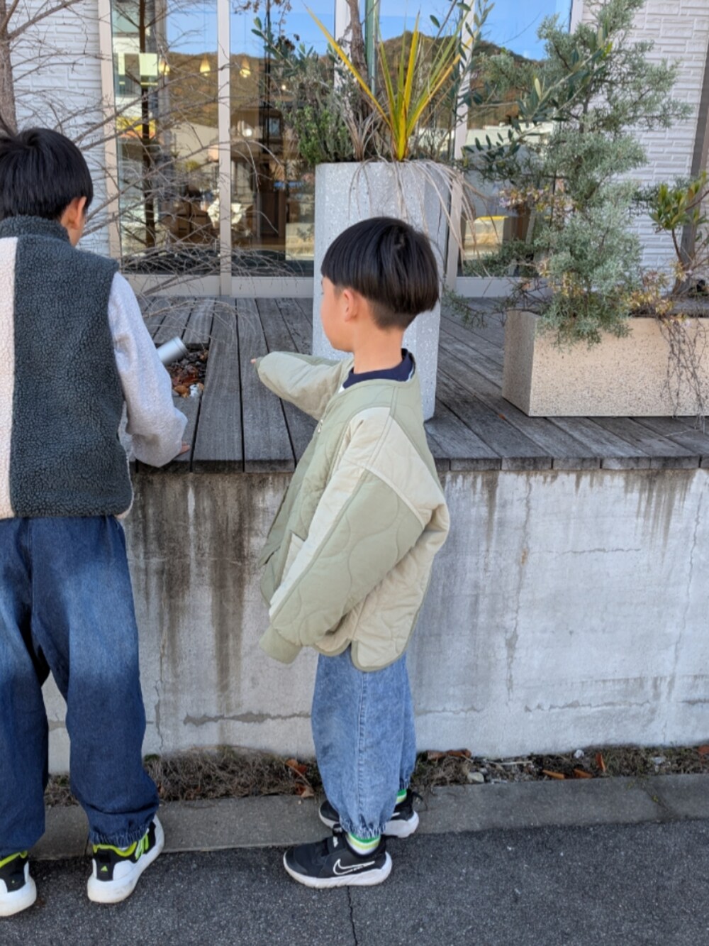 ホワイト系のスウェット、グリーン系のブルゾン、ブラック系のスニーカーを着用したキッズの秋コーディネートの3枚目の写真