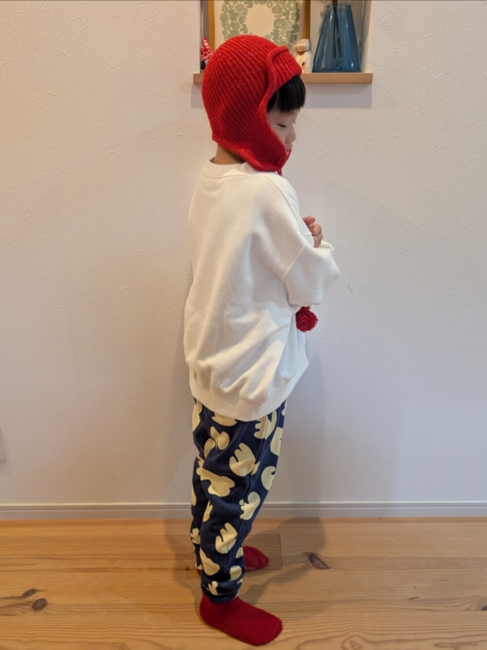 ホワイト系のスウェット、ブルー系のスウェットパンツ、レッド系のニットキャップ/ビーニーを着用したキッズの冬コーディネートの3枚目の写真