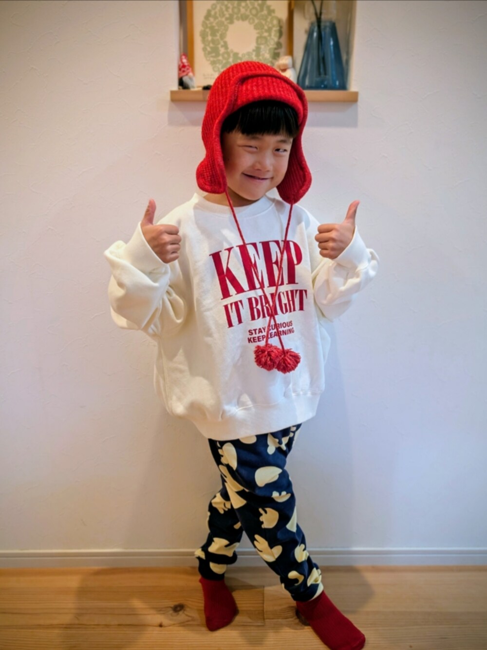 ホワイト系のスウェット、ブルー系のスウェットパンツ、レッド系のニットキャップ/ビーニーを着用したキッズの冬コーディネートの2枚目の写真