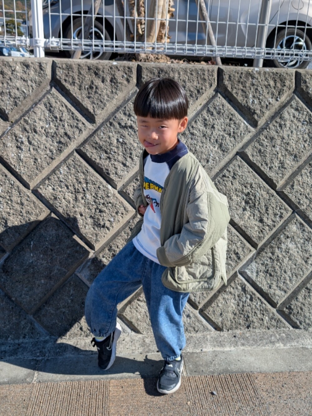 ホワイト系のスウェット、グリーン系のブルゾン、ブラック系のスニーカーを着用したキッズの秋コーディネートの2枚目の写真