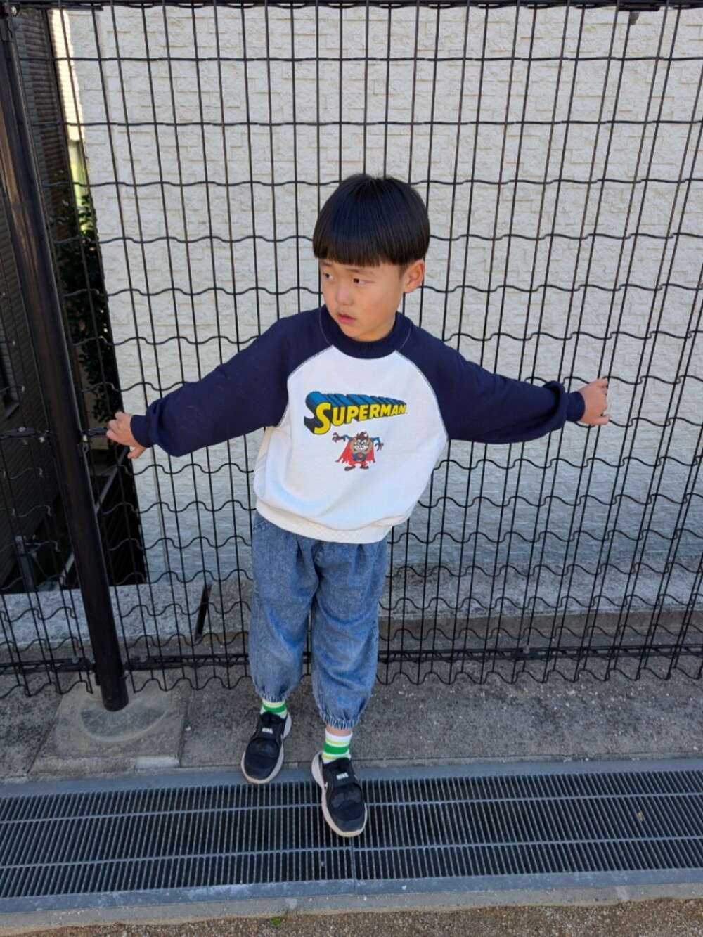 ホワイト系のスウェット、グリーン系のブルゾン、ブラック系のスニーカーを着用したキッズの秋コーディネートの4枚目の写真