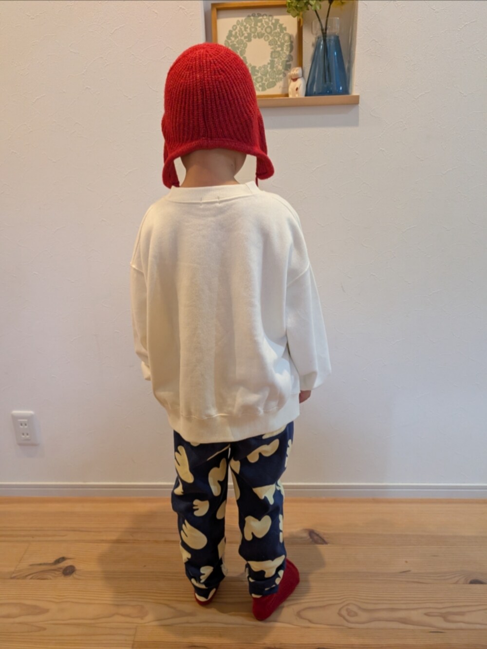 ホワイト系のスウェット、ブルー系のスウェットパンツ、レッド系のニットキャップ/ビーニーを着用したキッズの冬コーディネートの4枚目の写真