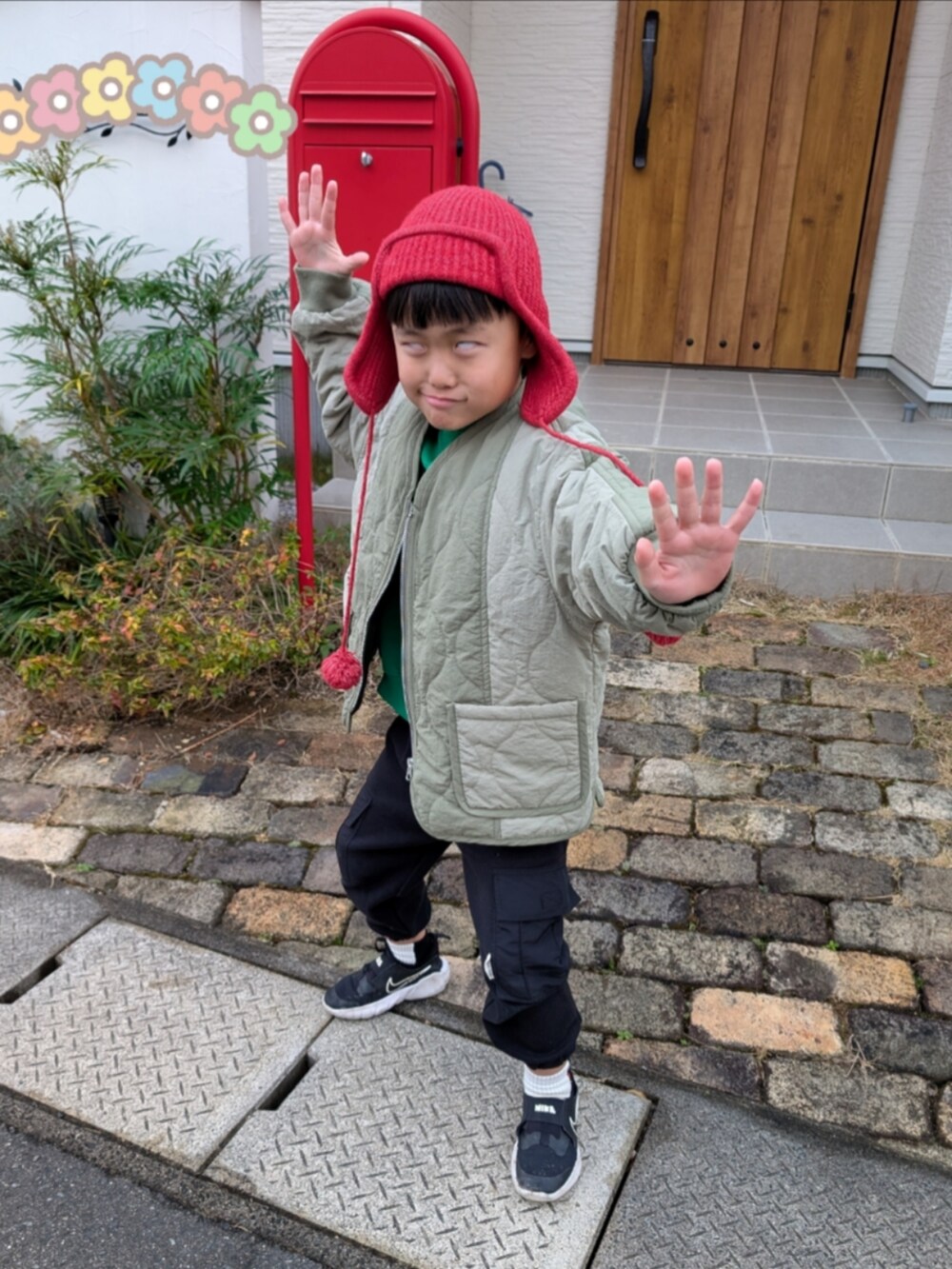 グリーン系のスウェット、ブラック系のパンツ、ブラック系のスニーカーを着用したキッズの冬コーディネートの4枚目の写真