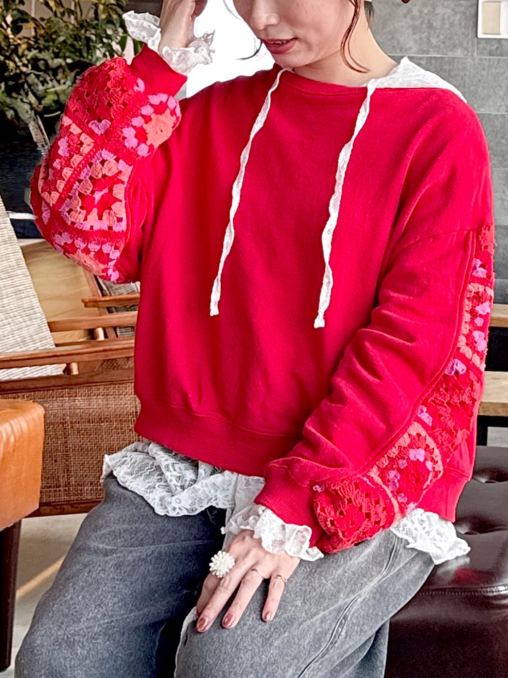 レッド系のスウェット、ホワイト系のTシャツ/カットソー、ベージュ系のキャップを着用したレディースの春コーディネートの2枚目の写真