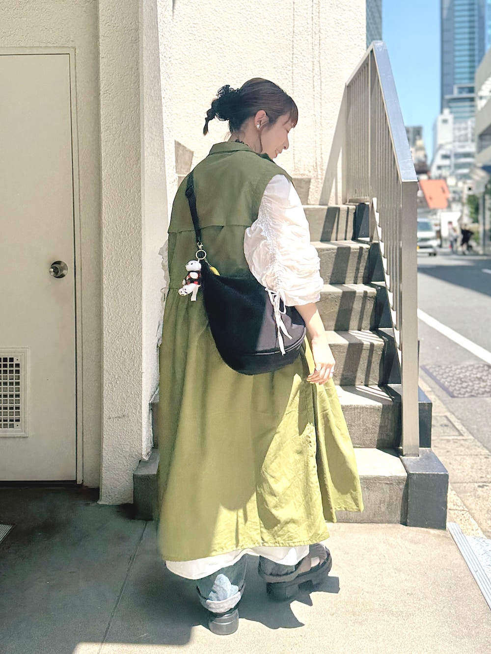ホワイト系のワンピース、グリーン系のその他アウター、ブラック系のショルダーバッグを着用したレディースの春コーディネートの2枚目の写真