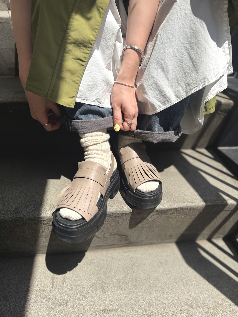 ホワイト系のワンピース、グリーン系のその他アウター、ブラック系のショルダーバッグを着用したレディースの春コーディネートの5枚目の写真