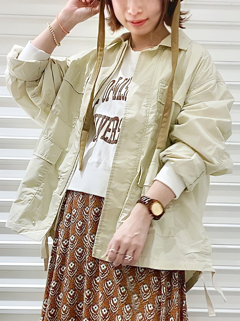 ホワイト系のスウェット、ホワイト系のシャツ/ブラウス、イエロー系のスカートを着用したレディースの冬コーディネートの2枚目の写真