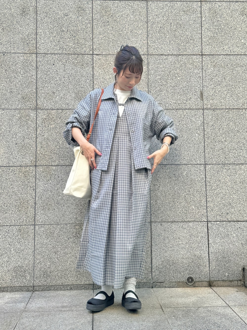 ブルー系のシャツ/ブラウス、ホワイト系のトートバッグ、ブルー系のジャンパースカートを着用したレディースの秋コーディネートの2枚目の写真