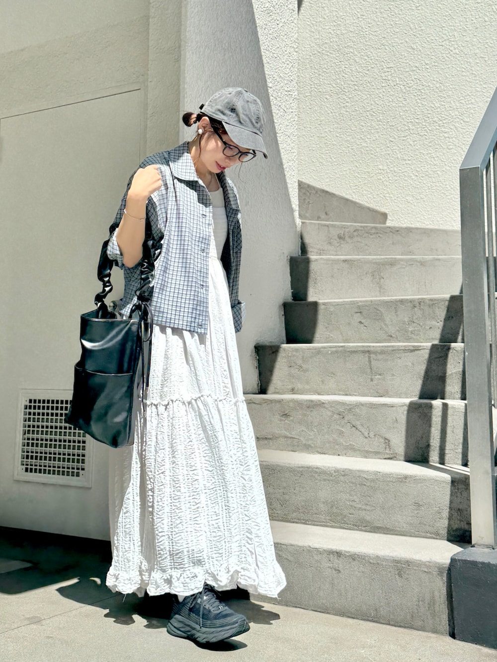 ブルー系のシャツ/ブラウス、ブラック系のスニーカー、ホワイト系のジャンパースカートを着用したレディースの秋コーディネートの2枚目の写真