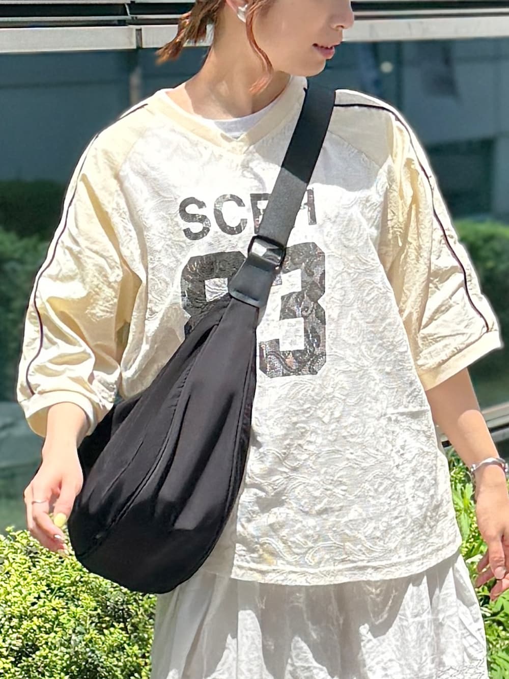 ベージュ系のTシャツ/カットソー、ホワイト系のスカート、ベージュ系のサンダルを着用したレディースの春コーディネートの3枚目の写真