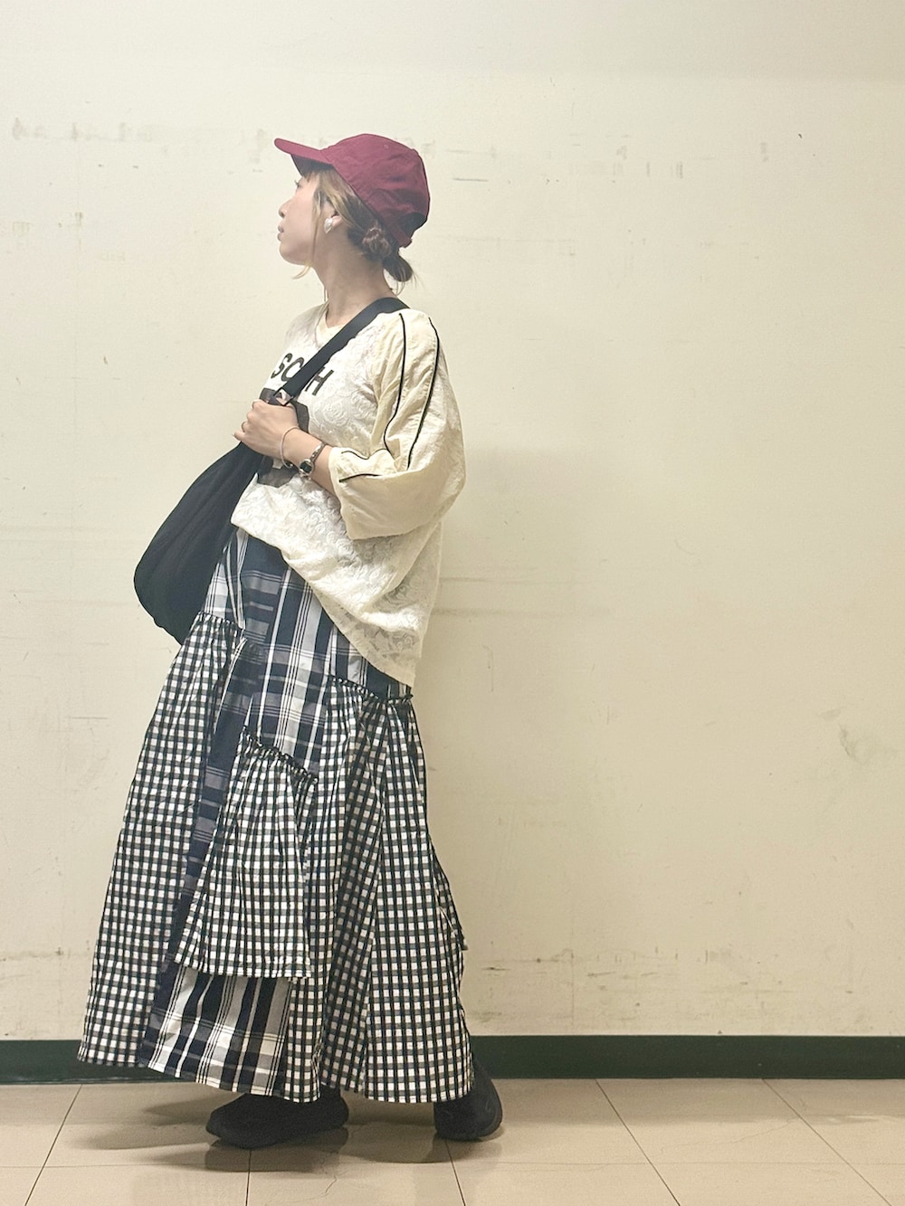 ブラック系のスカート、ベージュ系のTシャツ/カットソー、ブラック系のスニーカーを着用したレディースの夏コーディネートの2枚目の写真