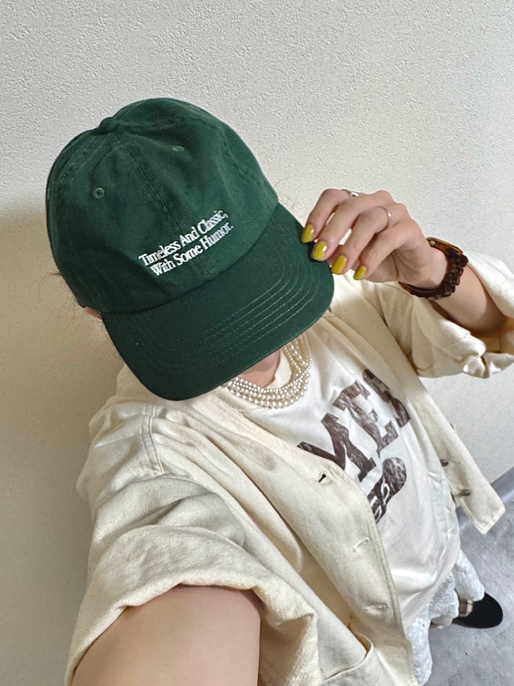 ホワイト系のベスト、ブラウン系のショルダーバッグ、ホワイト系のキャミソールを着用したレディースの秋コーディネートの3枚目の写真