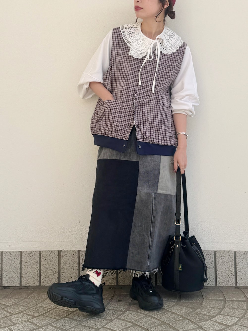 ホワイト系のTシャツ/カットソー、ブルー系のベスト、ブラック系のスニーカーを着用したレディースの春コーディネートの5枚目の写真