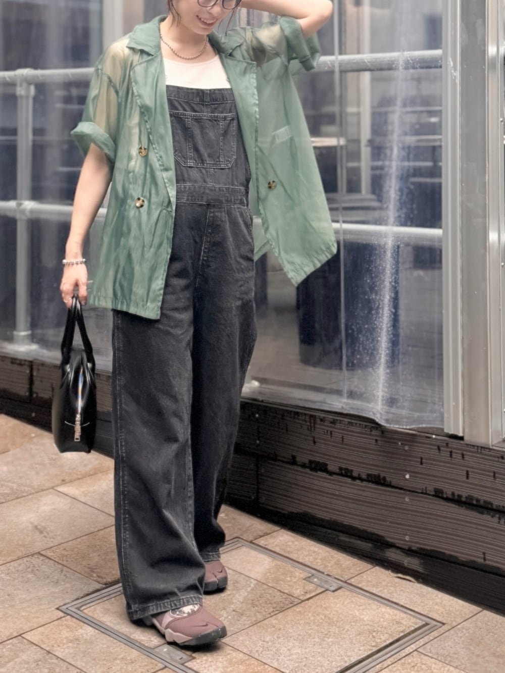 ブラック系のショルダーバッグ、ブラウン系のシューズ、ブラック系のサロペット/オーバーオールを着用したレディースの夏コーディネートの3枚目の写真