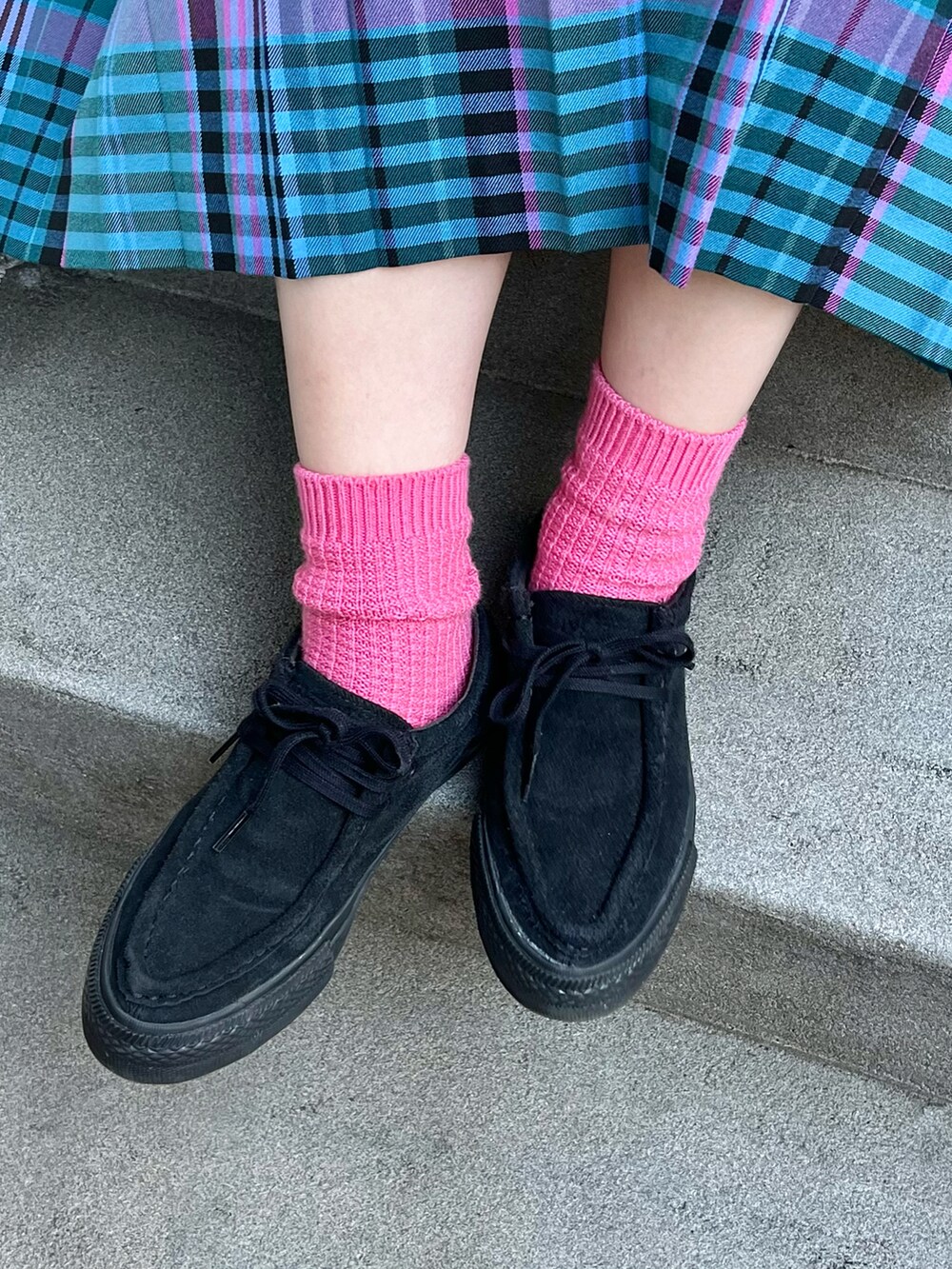 グレー系のスウェット、ブルー系のスカート、ブラック系のスニーカーを着用したレディースの冬コーディネートの3枚目の写真