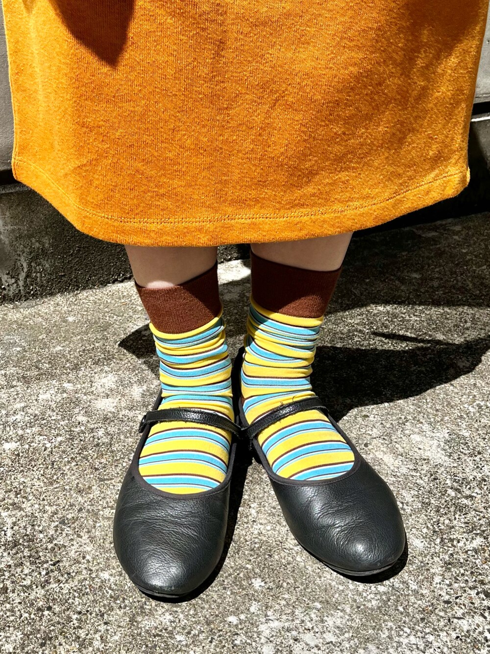 ホワイト系のTシャツ/カットソー、オレンジ系のスカート、ブラック系のバレエシューズを着用したレディースの春コーディネートの2枚目の写真