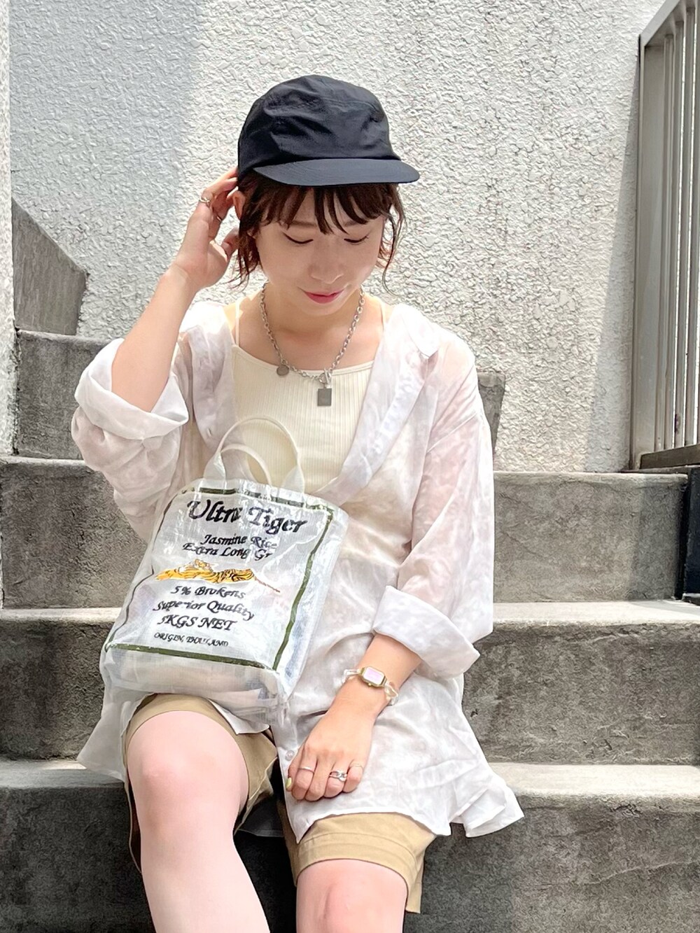 ベージュ系のシャツ/ブラウス、ホワイト系のキャミソール、ベージュ系のチノパンツを着用したレディースの夏コーディネートの3枚目の写真