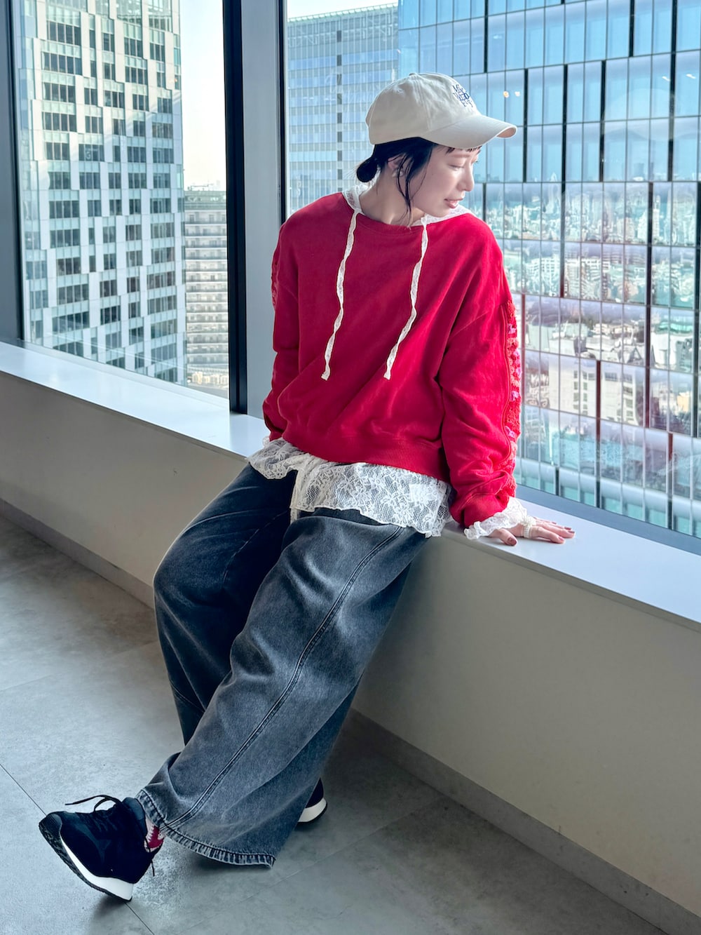 レッド系のスウェット、ホワイト系のTシャツ/カットソー、ベージュ系のキャップを着用したレディースの春コーディネートの3枚目の写真