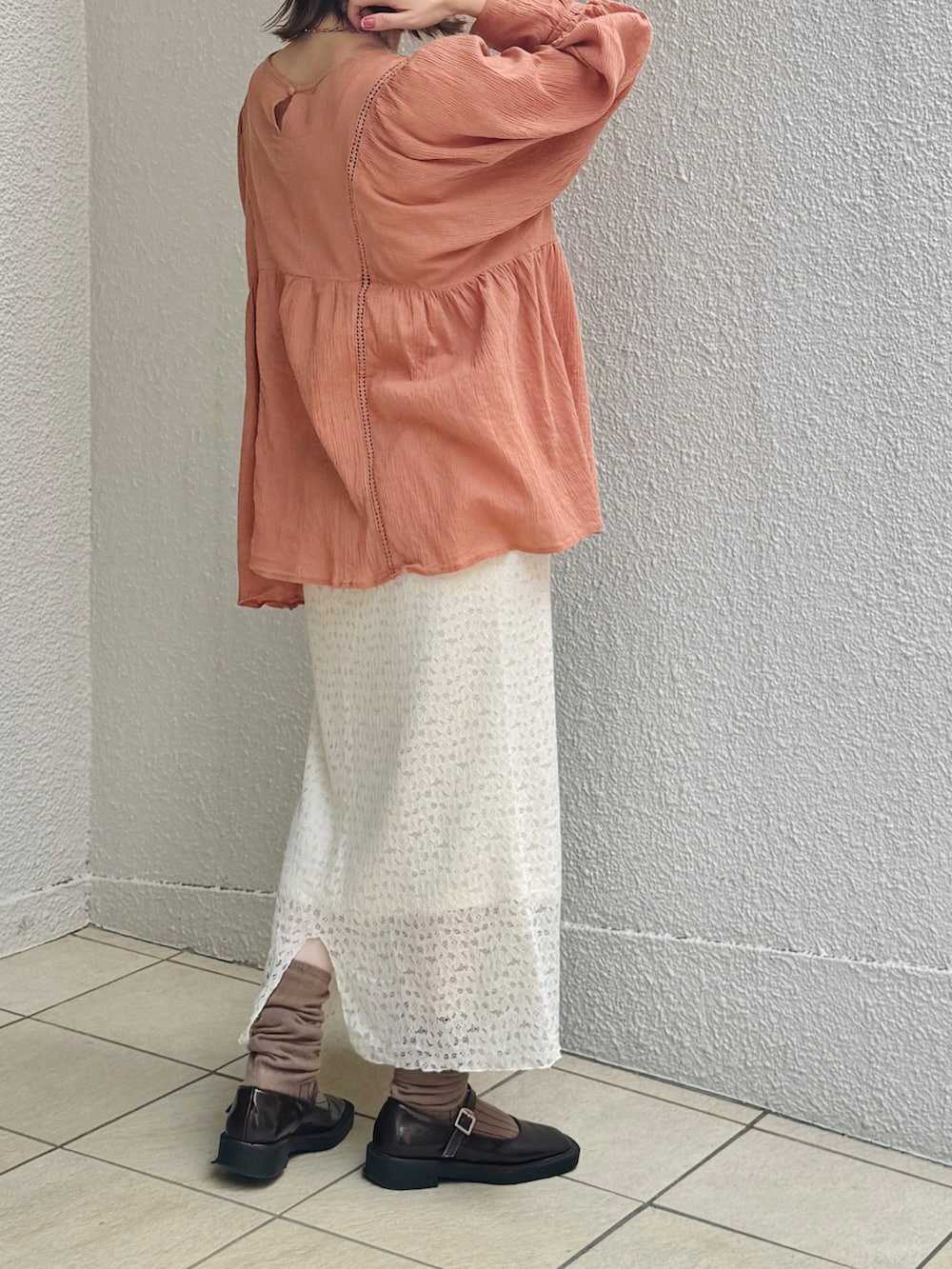 ホワイト系のスカート、ホワイト系のトートバッグ、ブラウン系のパンプスを着用したレディースの秋コーディネートの2枚目の写真