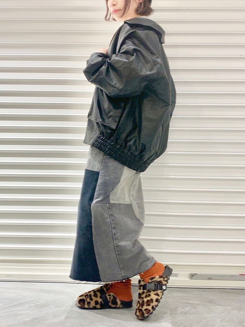 ベージュ系のスウェット、ブラック系のブルゾン、ブラック系のデニムスカートを着用したレディースの冬コーディネートの2枚目の写真