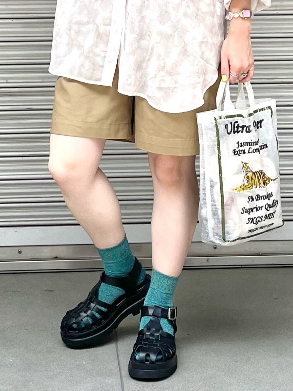 ベージュ系のシャツ/ブラウス、ホワイト系のキャミソール、ベージュ系のチノパンツを着用したレディースの夏コーディネートの2枚目の写真