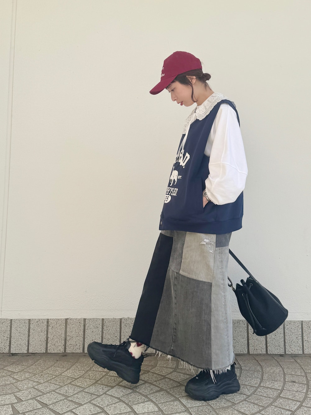 ホワイト系のTシャツ/カットソー、ブルー系のベスト、ブラック系のスニーカーを着用したレディースの春コーディネートの2枚目の写真