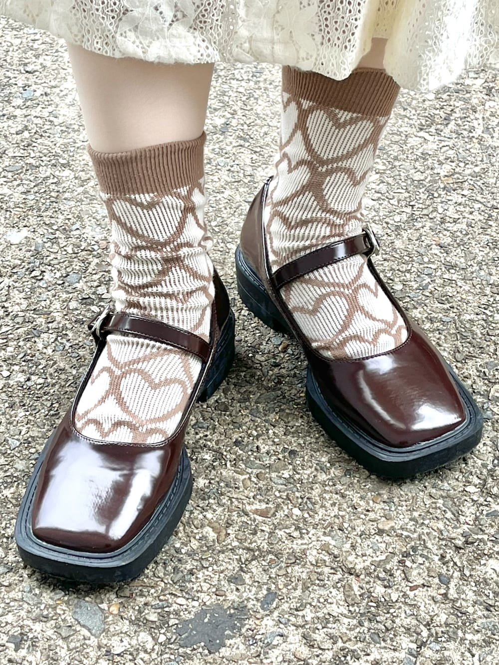 ホワイト系のノーカラーコート、ホワイト系のワンピース、ブラウン系のパンプスを着用したレディースの冬コーディネートの3枚目の写真