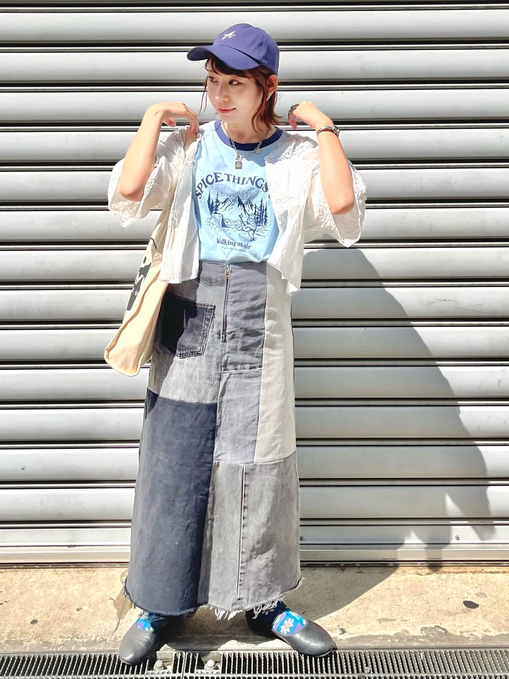 ブルー系のTシャツ/カットソー、ホワイト系のシャツ/ブラウス、ブラック系のデニムスカートを着用したレディースの秋コーディネートの2枚目の写真