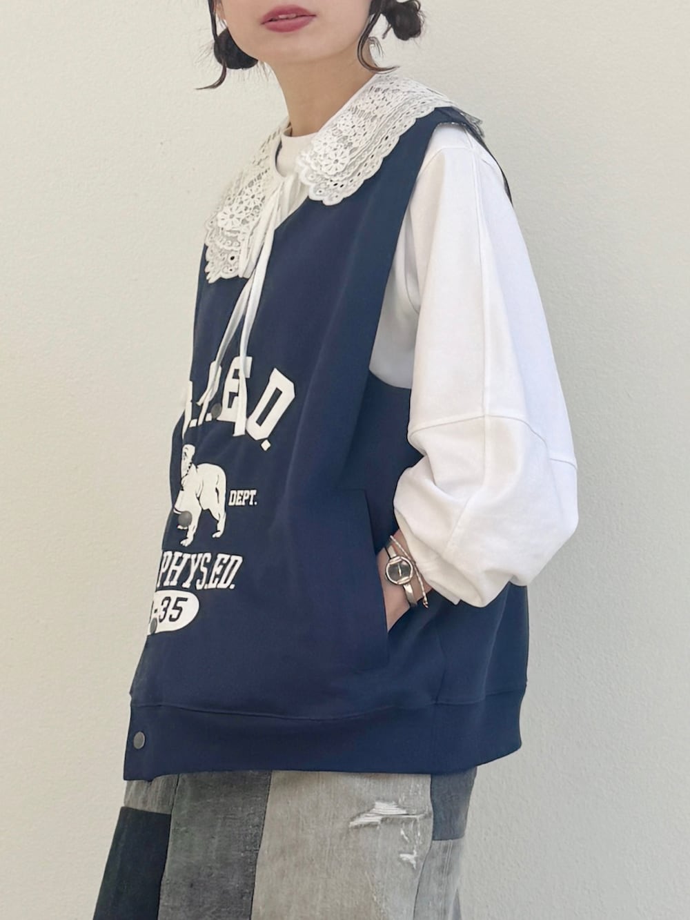 ホワイト系のTシャツ/カットソー、ブルー系のベスト、ブラック系のスニーカーを着用したレディースの春コーディネートの3枚目の写真