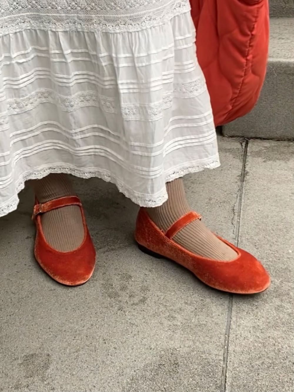 イエロー系のブルゾン、ホワイト系のスウェット、ホワイト系のスカートを着用したレディースの冬コーディネートの2枚目の写真