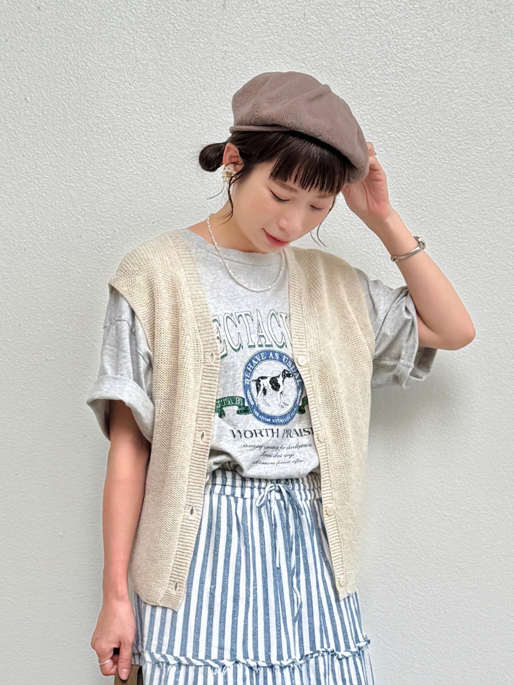 グレー系のTシャツ/カットソー、ホワイト系のベスト、ブラウン系のサンダルを着用したレディースの夏コーディネートの2枚目の写真