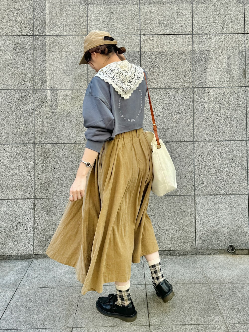 ブルー系のスウェット、ベージュ系のスカート、ブラック系のローファーを着用したレディースの秋コーディネートの3枚目の写真