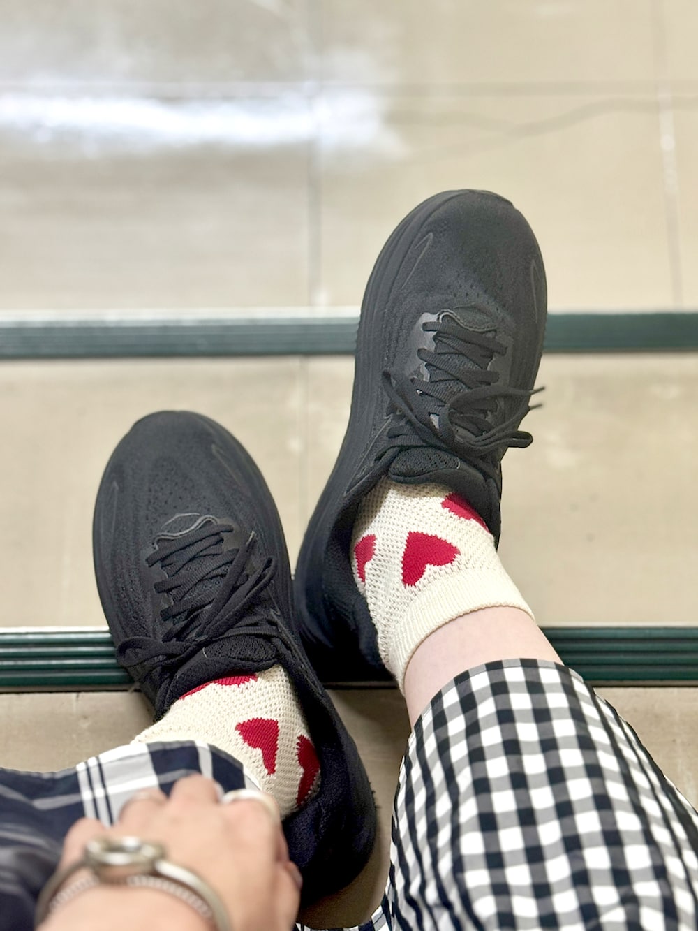 ブラック系のスカート、ベージュ系のTシャツ/カットソー、ブラック系のスニーカーを着用したレディースの夏コーディネートの3枚目の写真