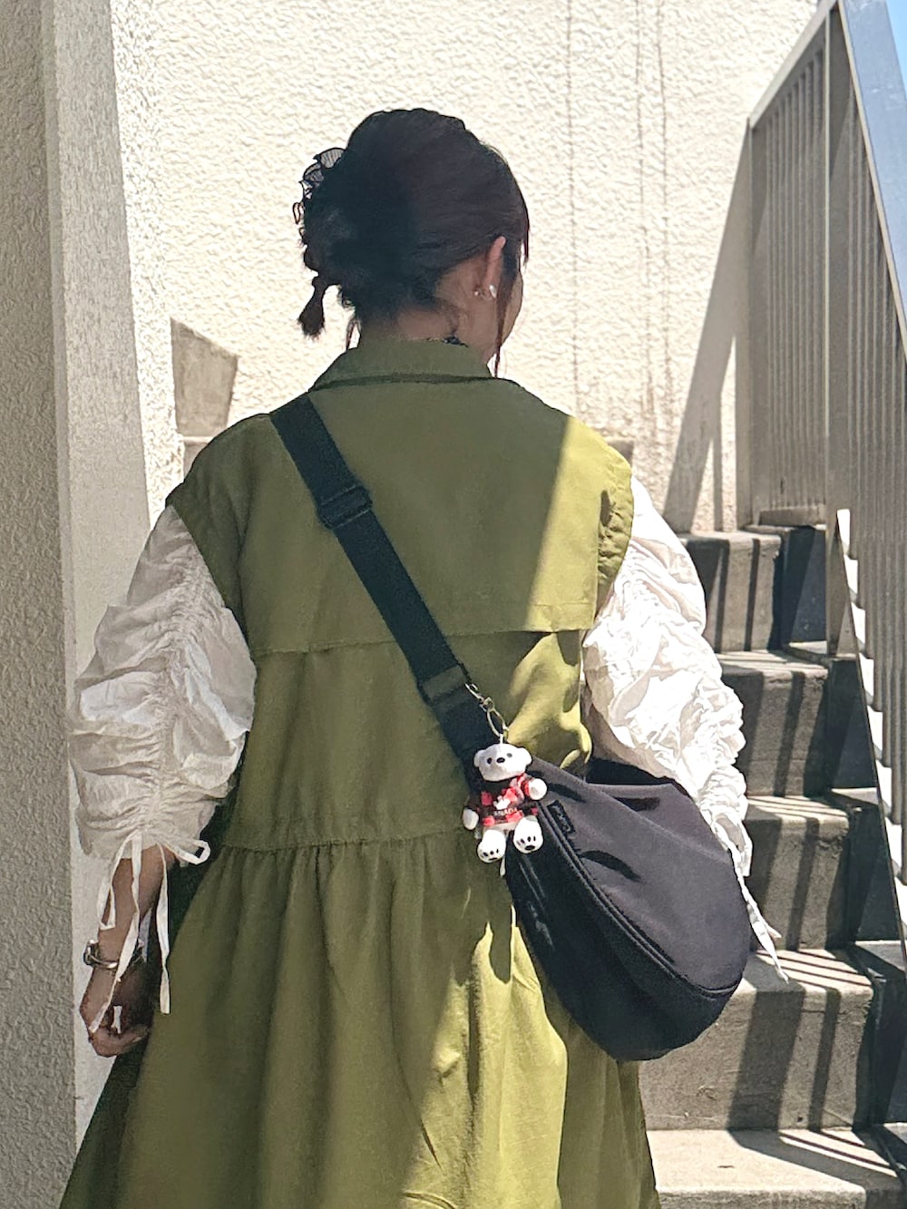 ホワイト系のワンピース、グリーン系のその他アウター、ブラック系のショルダーバッグを着用したレディースの春コーディネートの3枚目の写真