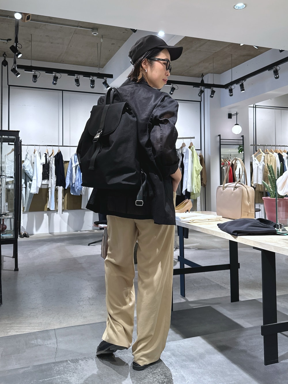 ブラック系のバックパック/リュック、ベージュ系のその他パンツ、ブラック系のテーラードジャケットを着用したレディースの春コーディネートの3枚目の写真