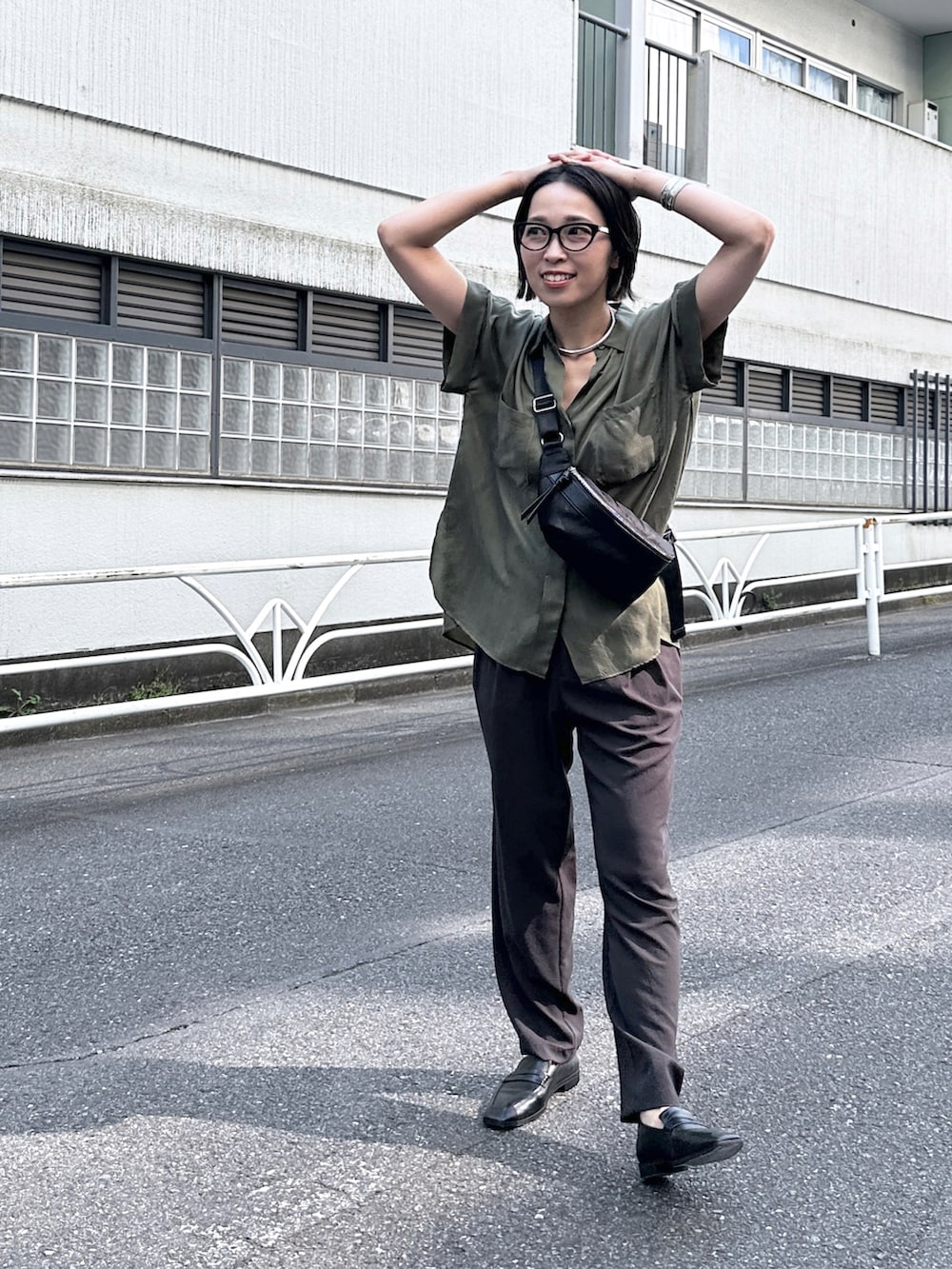 グリーン系のシャツ/ブラウス、グレー系のその他パンツ、ブラック系のローファーを着用したレディースの春コーディネートの2枚目の写真