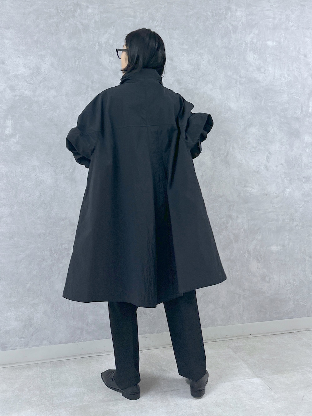 ブラック系のマウンテンパーカー、ブラック系のスラックス、ブラック系のトートバッグを着用したレディースの春コーディネートの4枚目の写真