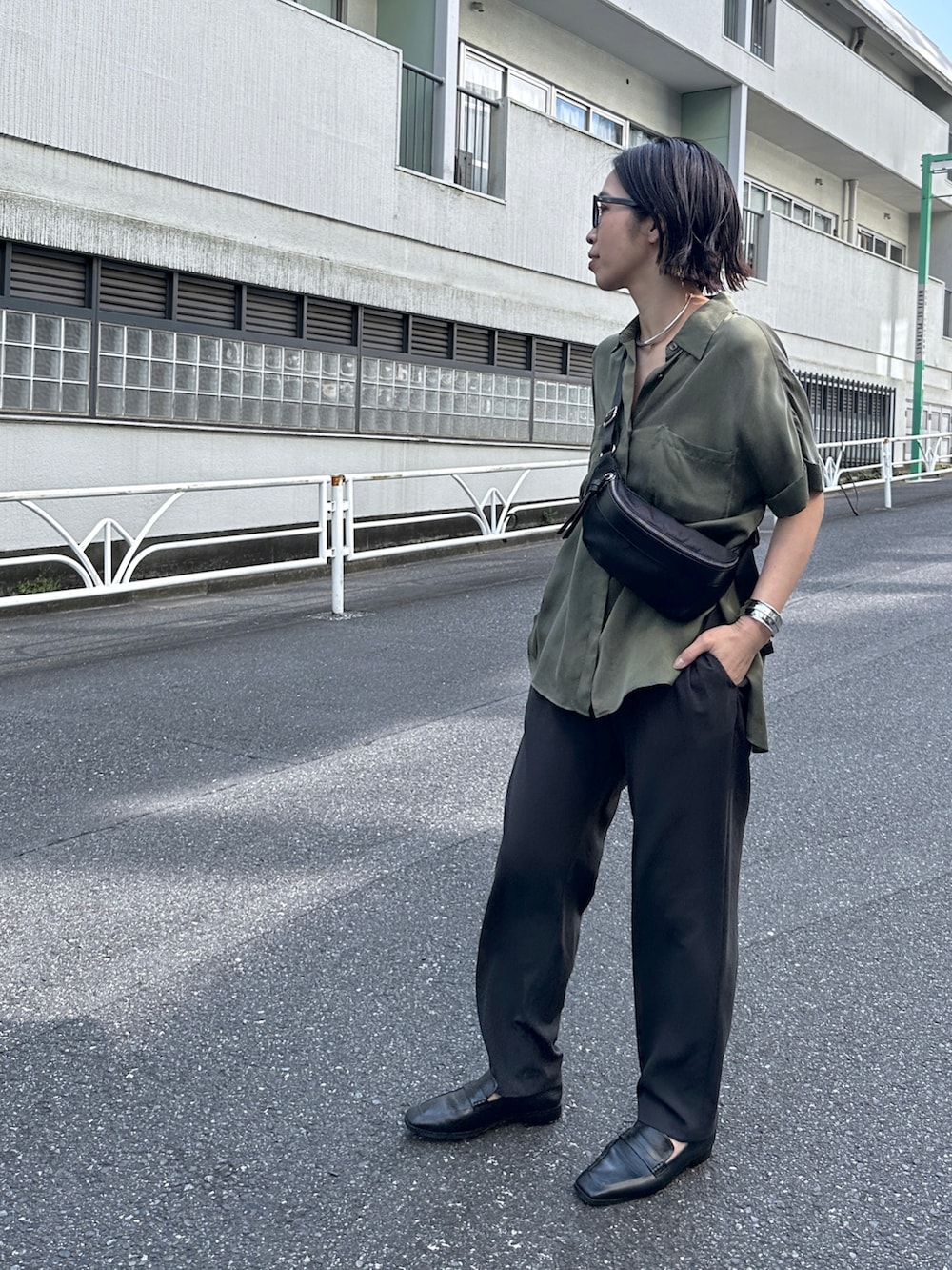 グリーン系のシャツ/ブラウス、グレー系のその他パンツ、ブラック系のローファーを着用したレディースの春コーディネートの3枚目の写真