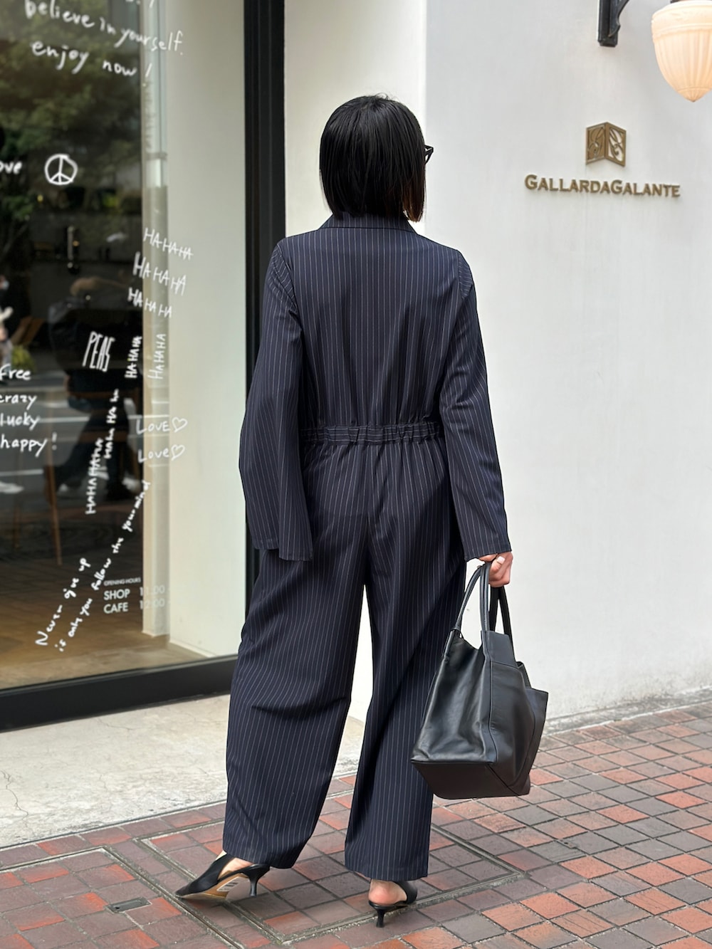 ブラック系のパンプス、ブラック系のトートバッグ、ブラック系のつなぎ/オールインワンを着用したレディースの冬コーディネートの2枚目の写真