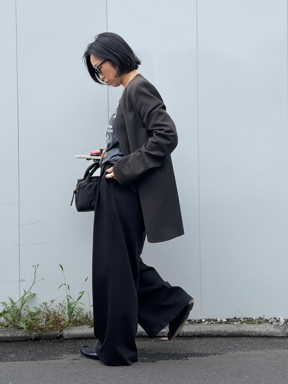 ブラック系のその他パンツ、ブラック系のバッグ、ブラック系のノーカラージャケットを着用したレディースの秋コーディネートの2枚目の写真