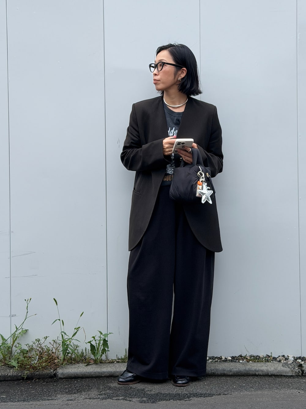 ブラック系のその他パンツ、ブラック系のバッグ、ブラック系のノーカラージャケットを着用したレディースの秋コーディネートの4枚目の写真