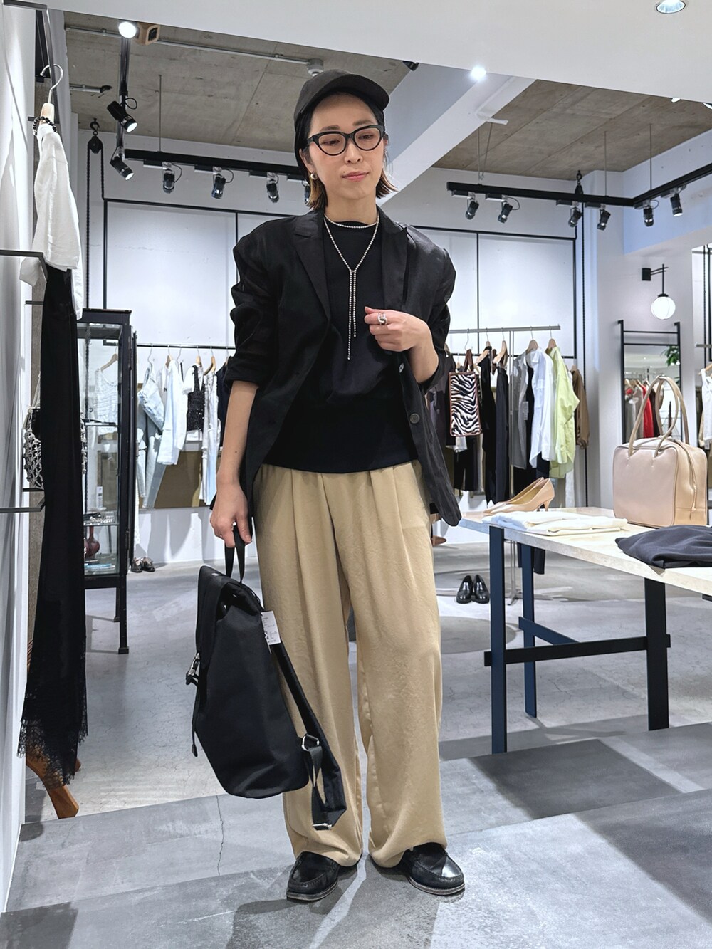 ブラック系のバックパック/リュック、ベージュ系のその他パンツ、ブラック系のテーラードジャケットを着用したレディースの春コーディネートの2枚目の写真