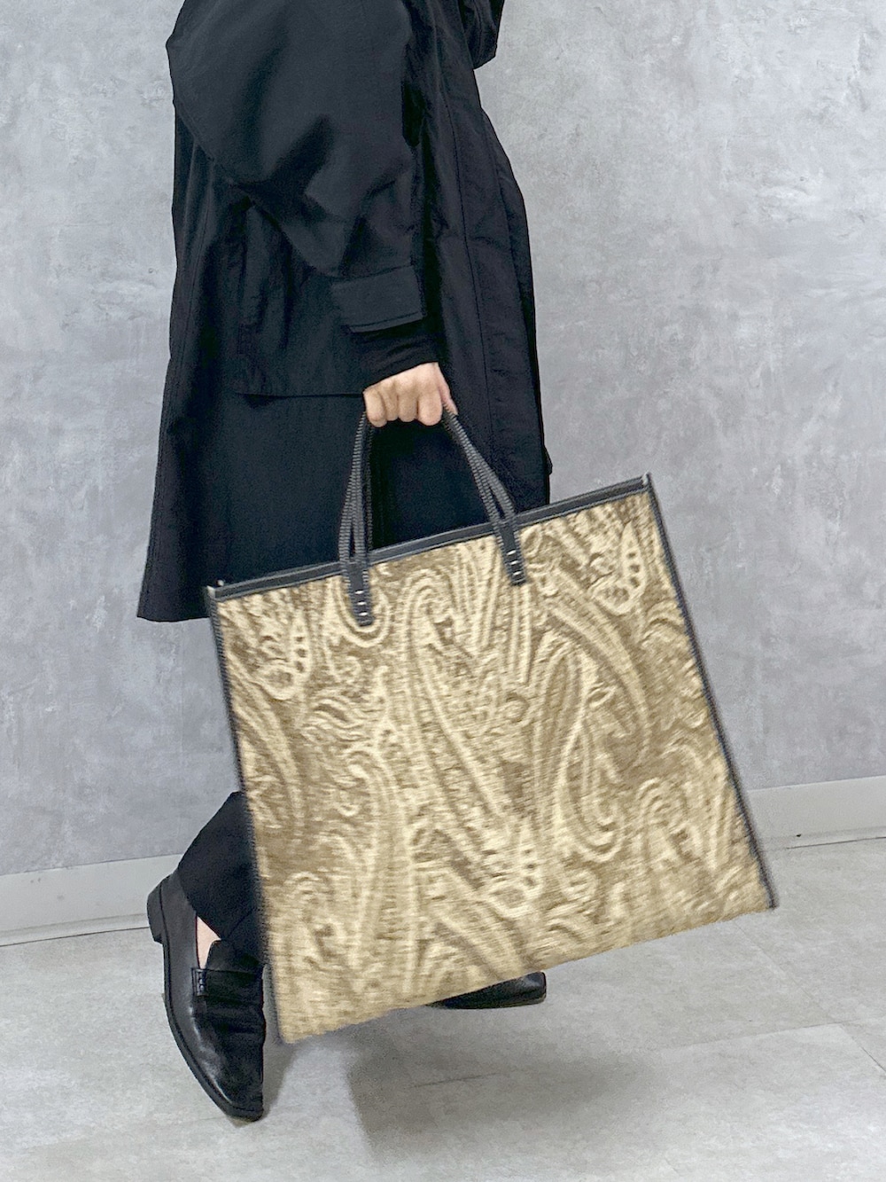 ブラック系のマウンテンパーカー、ブラック系のスラックス、ブラック系のトートバッグを着用したレディースの春コーディネートの5枚目の写真