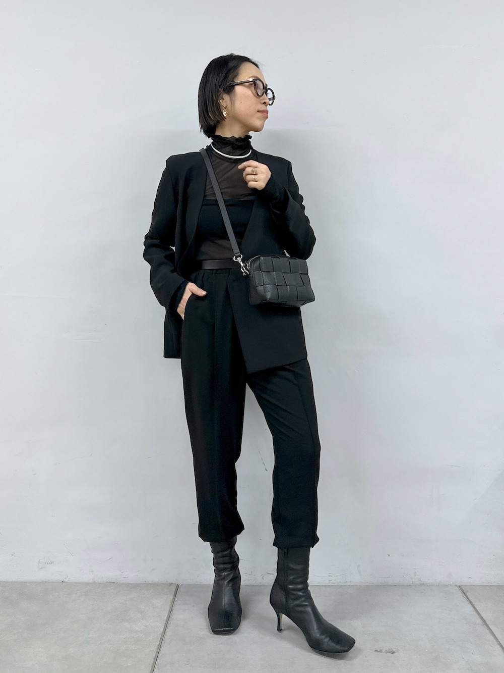 ブラック系のTシャツ/カットソー、ブラック系のパンツ、ブラック系のショルダーバッグを着用したレディースの冬コーディネートの2枚目の写真