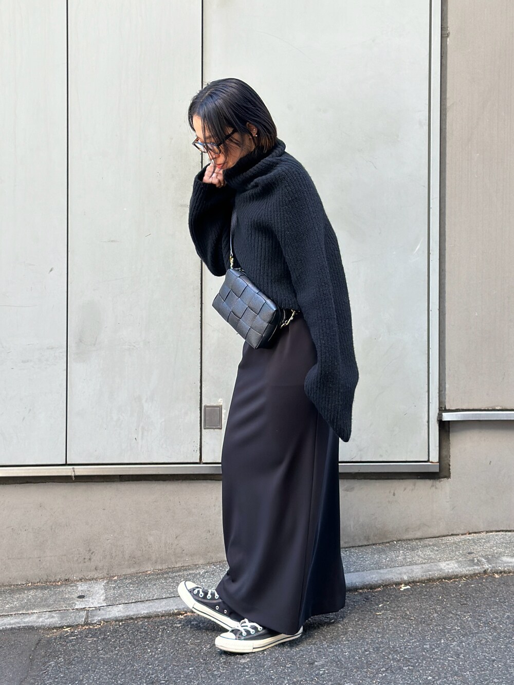 ブラック系のショルダーバッグ、ブラック系のニット/セーター、ブラック系のワンピースを着用したレディースの冬コーディネートの3枚目の写真