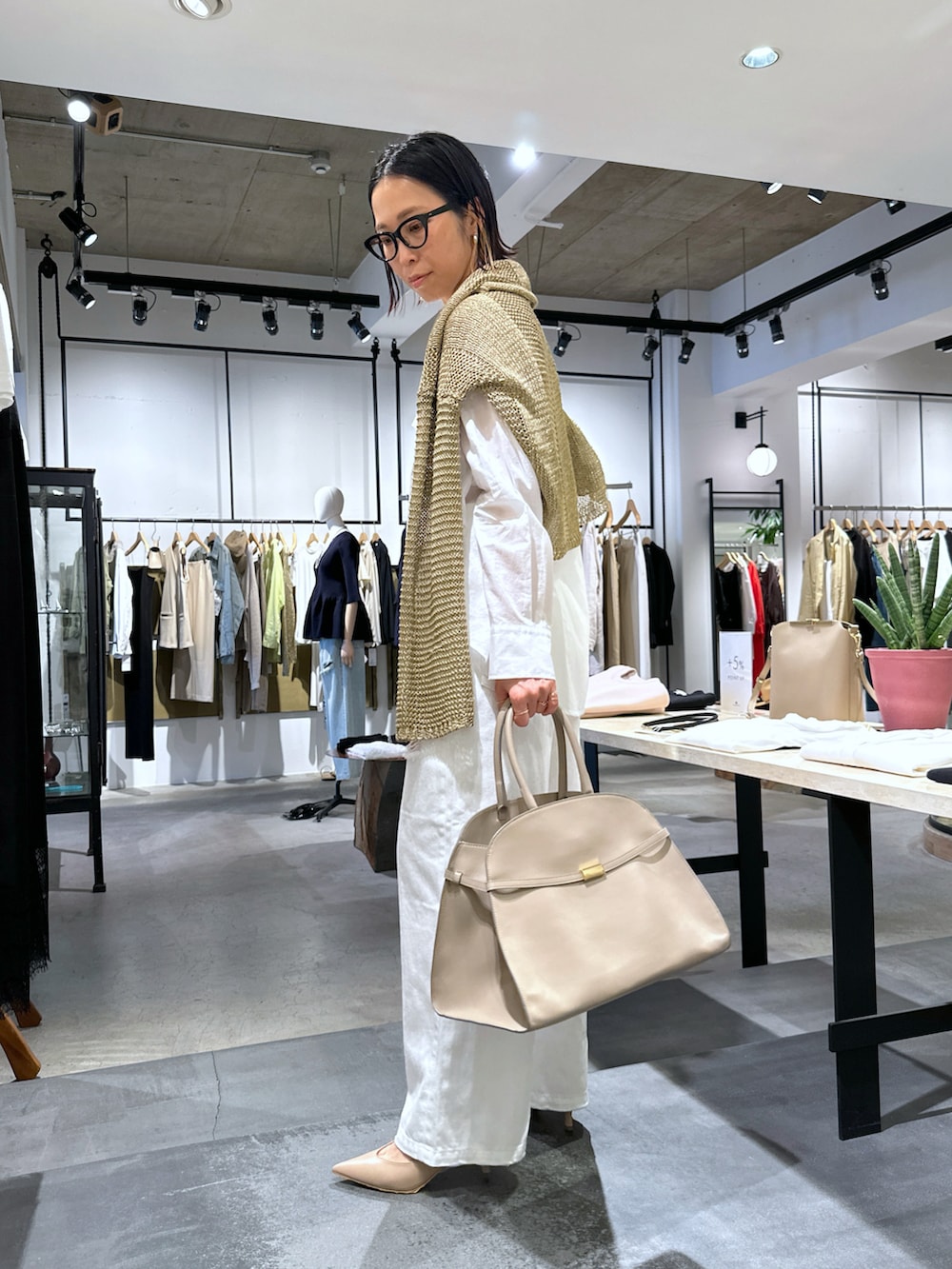 ホワイト系のデニムパンツ、ベージュ系のパンプス、ホワイト系のシャツ/ブラウスを着用したレディースの春コーディネートの2枚目の写真