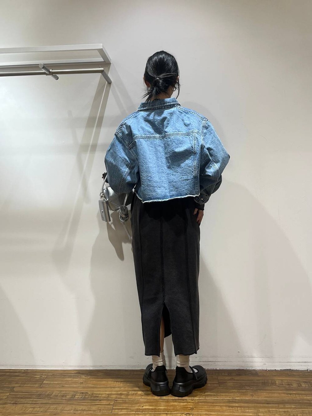 ブラック系のスニーカー、ブルー系のデニムジャケット、シルバー系のショルダーバッグを着用したレディースの冬コーディネートの4枚目の写真